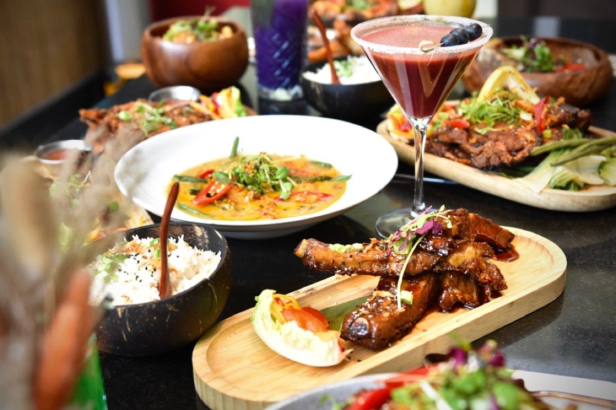 A Kultura feast with grilled dishes, curry and colourful cocktails